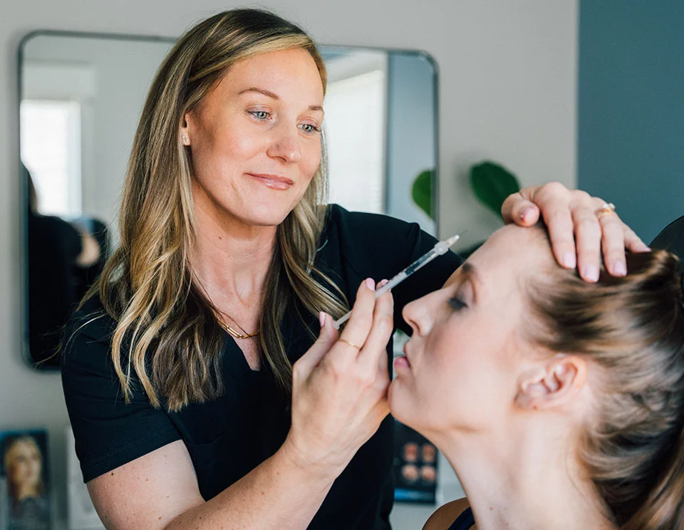 Female practitioner carefully administering an injectable treatment to a patient, with a focus on facial rejuvenation - Botox and Wrinkle Relaxers in Portsmouth, NH